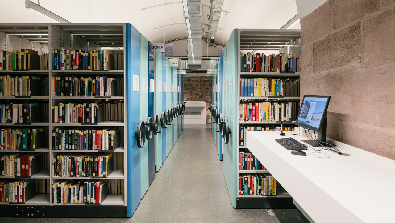 Kellergewölbe mit Bücherregalen/Kompaktusanlage im Ausleihzentrum Schloss Westflügel.